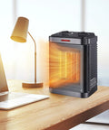 Tiny But Mighty 1500W PTC Ceramic Space Heater With Thermostat, 2S Rapid Heating on a desk near a lamp and laptop