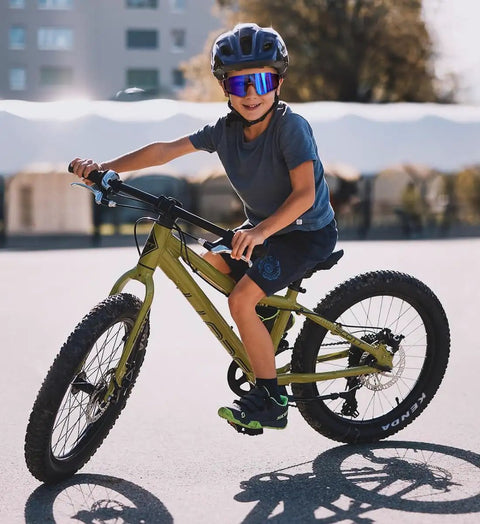 Child cycling wearing Kids Sports Sunglasses For Boys And Girls Youth Baseball And Softball Eyewear With UV400 Protection