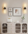 Mermiviok Matte Black Wall Sconces Set of 2, Clear Glass Vanity Lights mounted on a stylish wall above a modern sideboard.