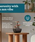 Tabletop Water Fountain With Three Tiers For Indoor Zen Waterfall Vibe, placed on a wooden table, with river rocks and plants nearby.