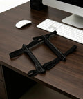 Game Changer Under Desk Computer Tower Stand For PC Hanging Bracket With Quick Lock Strap on a desk surface, ready for use.