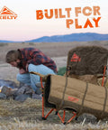 Lowdown Chair With Durable Bungee Cord Build In Beluga Color For Outdoor Concerts Sidelines And Lounging At Home One Foot Off The Ground Slight Recline Pet And Kid Friendly Built To Last next to a campfire with mountain backdrop