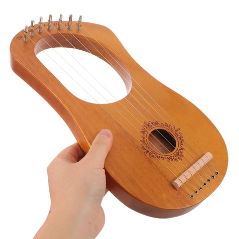 Hand holding a Portable 7-String Lyre Harp Kit For Adults with wooden body and metal strings, showing engraved design.