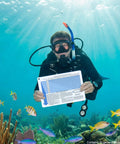 Scuba diver holding the No Decompression Dive Table In Feet With Instructions Imperial Dive Planner underwater