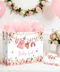 13 Inch Pink Floral Baby Gift Bag With Sturdy Handles Includes Matching Card And Three Sheets Of Tissue Paper on table