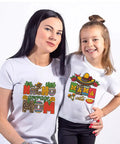 Mother and daughter wearing Cinco De Mayo iron-on transfers on white t-shirts, vibrant DIY crafts, festive designs, Mexico theme.