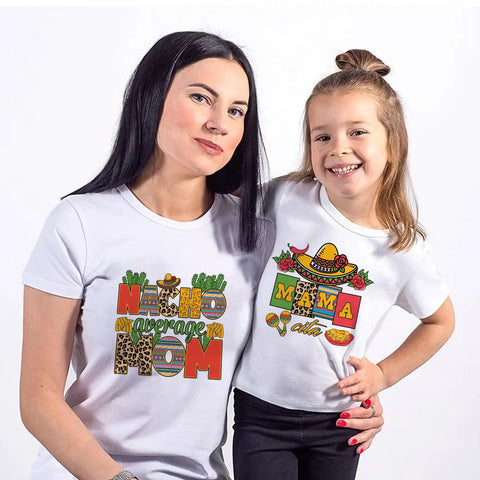 Mother and daughter wearing Cinco De Mayo iron-on transfers on white t-shirts, vibrant DIY crafts, festive designs, Mexico theme.