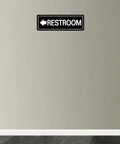 Left Arrow Restroom Sign For Businesses Durable Frosted Acrylic With Super Strong Self Adhesive Simple Fast Install 9 By 3 Inches Black Directional Office And Commercial Premises Sign mounted on wall