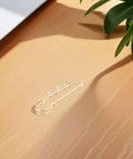 Top Shelf Loop Safety Pin Brooch Set Of Twenty Pieces Electroplated In Rich Golden Tone For Sweaters Coats And Jackets Featuring Reliable Non Slip Clasp To Keep Your Threads Secure on wooden surface.