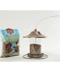 Real Deal Backyard Wild Bird Food Mix Featuring Natural Cherry Flavor And Hearty Sunflower in a tube feeder with a bag of seed.