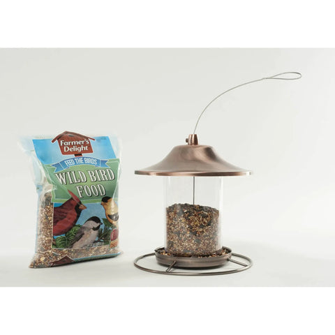 Real Deal Backyard Wild Bird Food Mix Featuring Natural Cherry Flavor And Hearty Sunflower in a tube feeder with a bag of seed.