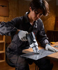 Person using Electric Metal Shear With 360 Degree Swivel Head, 4.0 Amp Corded Sheet Metal Cutter on a steel sheet.