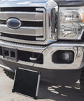 Heavy Duty Five Watt Solar Battery Trickle Charger With Overcharge Guard mounted on a truck front bumper.