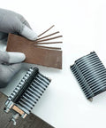 Person using Pro Grade Leather Tabletop Fringe Cutter for lace belts and strips with leather piece and blades visible.