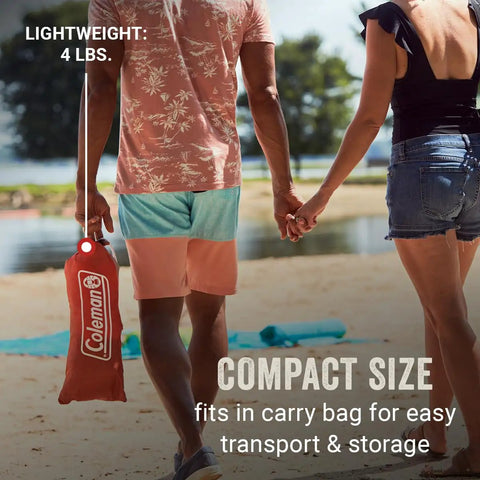 Lightweight Beach Shade Tent With Pre Attached Poles Large Sun Shelter in compact carry bag held by couple on beach