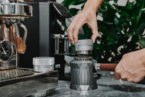 Using 53mm Gravity Adaptive Espresso Distributor for 54mm Portafilters in Breville Bottomless setup, stainless steel tool on countertop