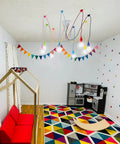Colorful eight-arm spider pendant light chandelier for kids room with adjustable wires, multicolor finish, E26 base installed on ceiling.