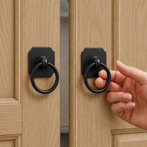 Hand reaching for 2 Pack Matte Black Ring Pull Cabinet Handles With 1.6 Inch Backplates No Fuss Modern Drawer Pulls on wood doors
