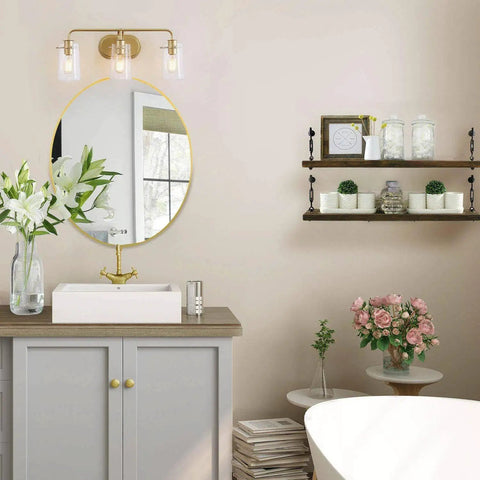 Three Light Gold Vanity Light With Seeded Glass Shades in bathroom with mirror, flowers, and shelves.