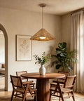 DLITISH 19'' Hand Woven Rattan Pendant Light with Glass Shade above a dining table in a cozy interior.
