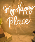 My Happy Place Neon Sign Warm White Neon Lights For Bedroom Decor Cozy Home Office Wall Art Wedding And Birthday Party Decor Gift For Girls Room Modern Neon Wall Sign glowing on a furry background with books and decor