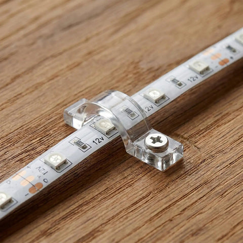 Clear Rope Light Clips Kit 100 Pack Transparent Mounting Brackets With 100 Screws for easy DIY install shown on wood surface