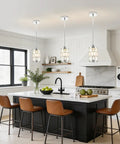 etiruety Adjustable Modern Crystal Chrome Pendant Lights Kitchen Island above a marble countertop with brown bar stools.