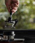 Top Shelf 58Mm Needle Distributor And Wdt Espresso Tool in use, adjustable height, stainless steel ground prep kit with cleaning base.