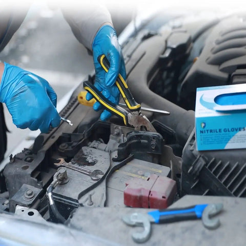 Mechanic wearing Heavy Duty Nitrile Disposable Gloves 4 Mil Thick working on car engine, box of gloves beside.