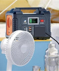 Portable Ac Power Station With Fast Charging Ports connected to a small white fan on a tabletop.