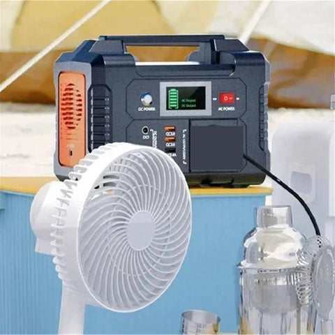 Portable Ac Power Station With Fast Charging Ports connected to a small white fan on a tabletop.
