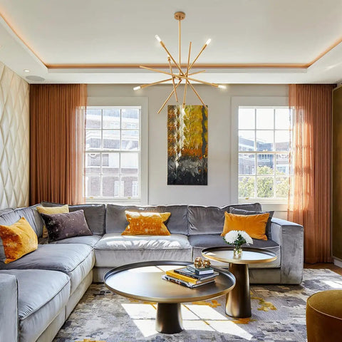 Modern living room with grey sofa, orange cushions, abstract art, and Dimmable E12 LED Bulb 8W Equal 100W Daylight chandelier
