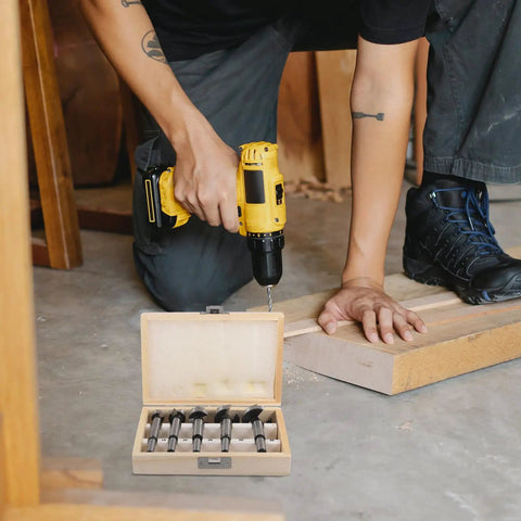 Person using a drill with Top Shelf 5 Piece Forstner Drill Bit Set Woodworking Hinge Cutter Round Shank Multi Tooth Bits For Hardwood Softwood Plywood Delivers Knockout Precision And Solid Wooden Carrying Case.