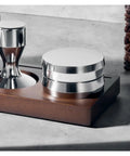 Next Level 58.5Mm Espresso Distribution Tool And Coffee Leveler on a wood base, showcasing sleek stainless steel design.