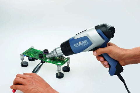 Person using Heavy Duty 2200W Hot Air Gun With Variable Temperature 60C To 630C, LCD Display, Three Airflow Speeds on PCB