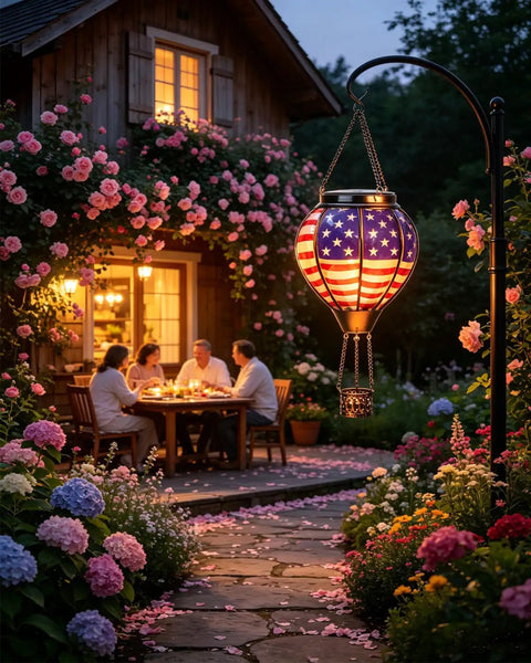 Solar Hot Air Balloon Lantern With Flickering Flame, Glass Outdoor Hanging Lantern illuminating a garden with people dining al fresco