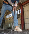 Worker using Round Three Quarter Inch Thirty Inch Connecting Bar With Fifteen Degree Angled Chisel End For Easy Alignment Prying And Chiseling Made In USA Sleever Bar on steel grid.