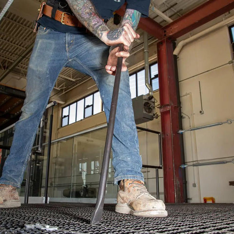 Worker using Round Three Quarter Inch Thirty Inch Connecting Bar With Fifteen Degree Angled Chisel End For Easy Alignment Prying And Chiseling Made In USA Sleever Bar on steel grid.