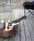 Stainless Steel Wood Burning Fire Pit With Stand And Carry Bag Portable Outdoor Heater shaped like a guitar for patio use.