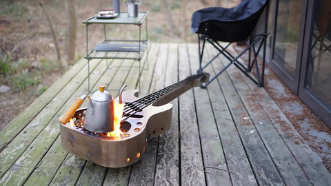 Stainless Steel Wood Burning Fire Pit With Stand And Carry Bag Portable Outdoor Heater shaped like a guitar for patio use.