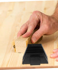 Hand sanding wood with black modular wrench organizer rack on wooden surface.