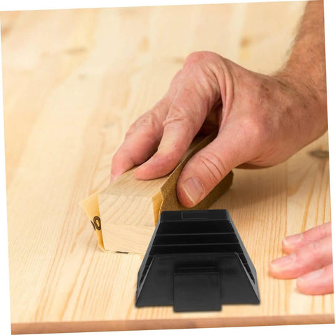 Hand sanding wood with black modular wrench organizer rack on wooden surface.