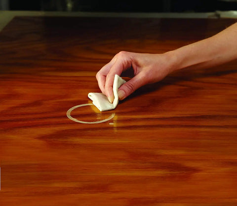 Hand using Reusable Water Mark Remover Cloth For Wood Care, Fix White Rings And Haze From Moisture And Heat on wooden surface
