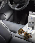 ZEISS Lens Wipes box with two sachets and tortoiseshell sunglasses on a car center console.