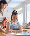 Teacher assisting student with Bulk 60 Sheets Rustic Classroom Name Plates For Desks And Tags Die Cut Flat Nameplates on desk