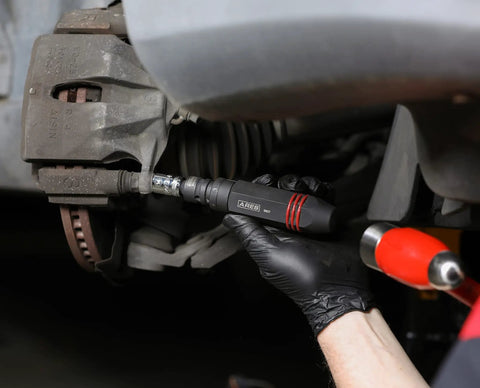 Three Eighths Inch Drive Manual Reversible Impact Driver Kit loosening rusted fasteners on car brakes by mechanic