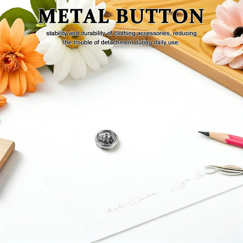Single silver metal snap fastener on white surface for clothes and crafts