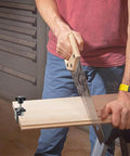 Man woodworking with a saw, using a Set Of 4 Heavy Duty C Clamps For Woodworking And Metalworking, black aluminum alloy clamp on a wooden board.