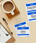 Customizable Hello My Name Is Name Tags White With Blue Border Removable Adhesive For Laser And Inkjet Printing 100 Pack Perfect For Conferences Networking Reunions And Events next to a cup and clipboard.