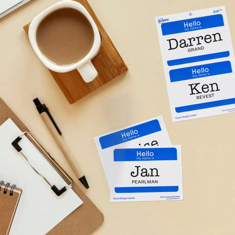 Customizable Hello My Name Is Name Tags White With Blue Border Removable Adhesive For Laser And Inkjet Printing 100 Pack Perfect For Conferences Networking Reunions And Events next to a cup and clipboard.